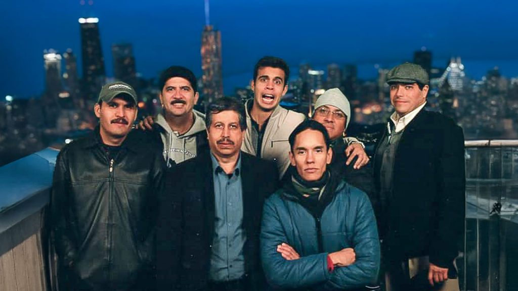 Equipo de Maqpower posando para una foto frente a un fondo de edificios iluminados de noche.