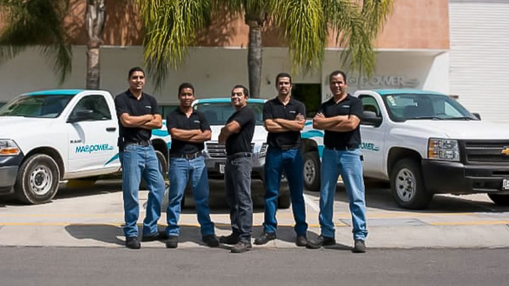 Equipo de Maqpower Sonriendo Frente a la Flotilla Comercial