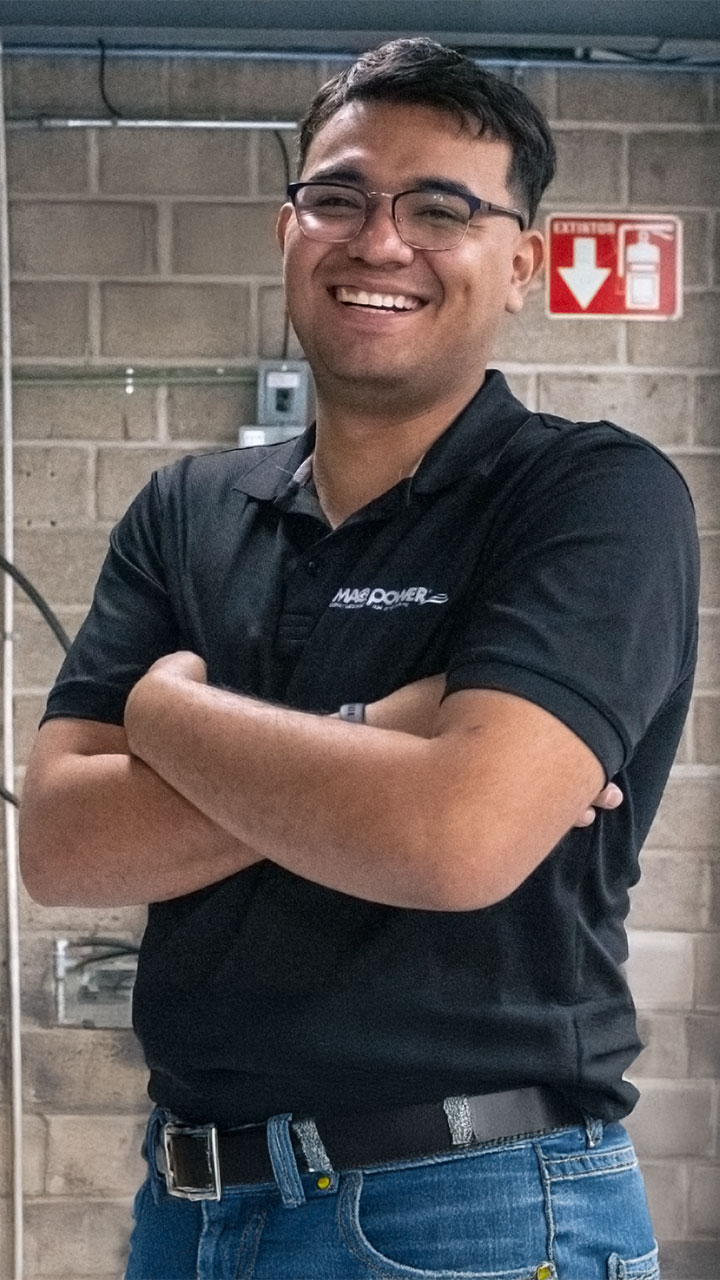 Colaborador de Maqpower sonriendo mientras cruza los brazos.