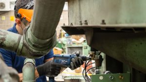 Técnico de Maqpower dando mantenimiento preventivo a equipo Sullair de aire comprimido.